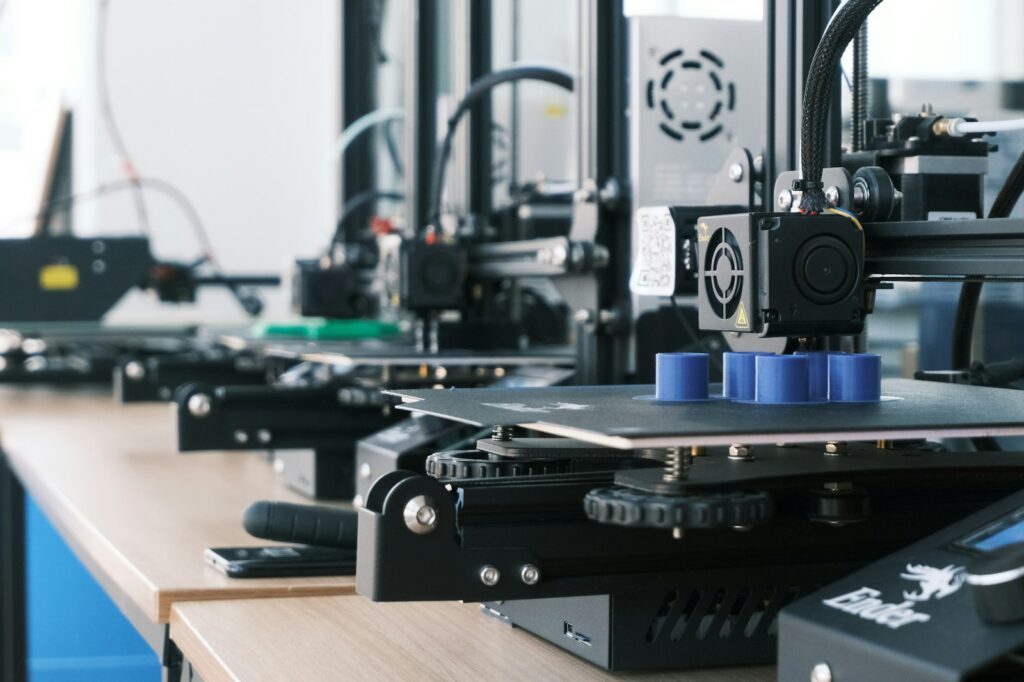 Row of 3D printers producing prototype parts on a workshop bench