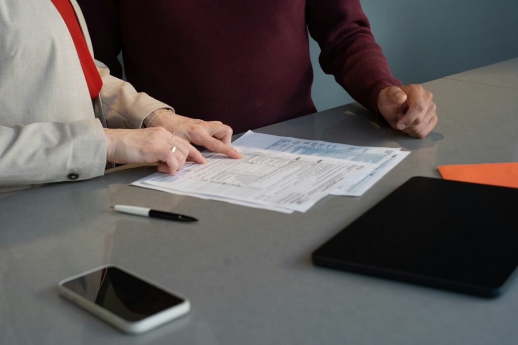 Two people reviewing printed quality records at a table during an ISO 13485 internal audit