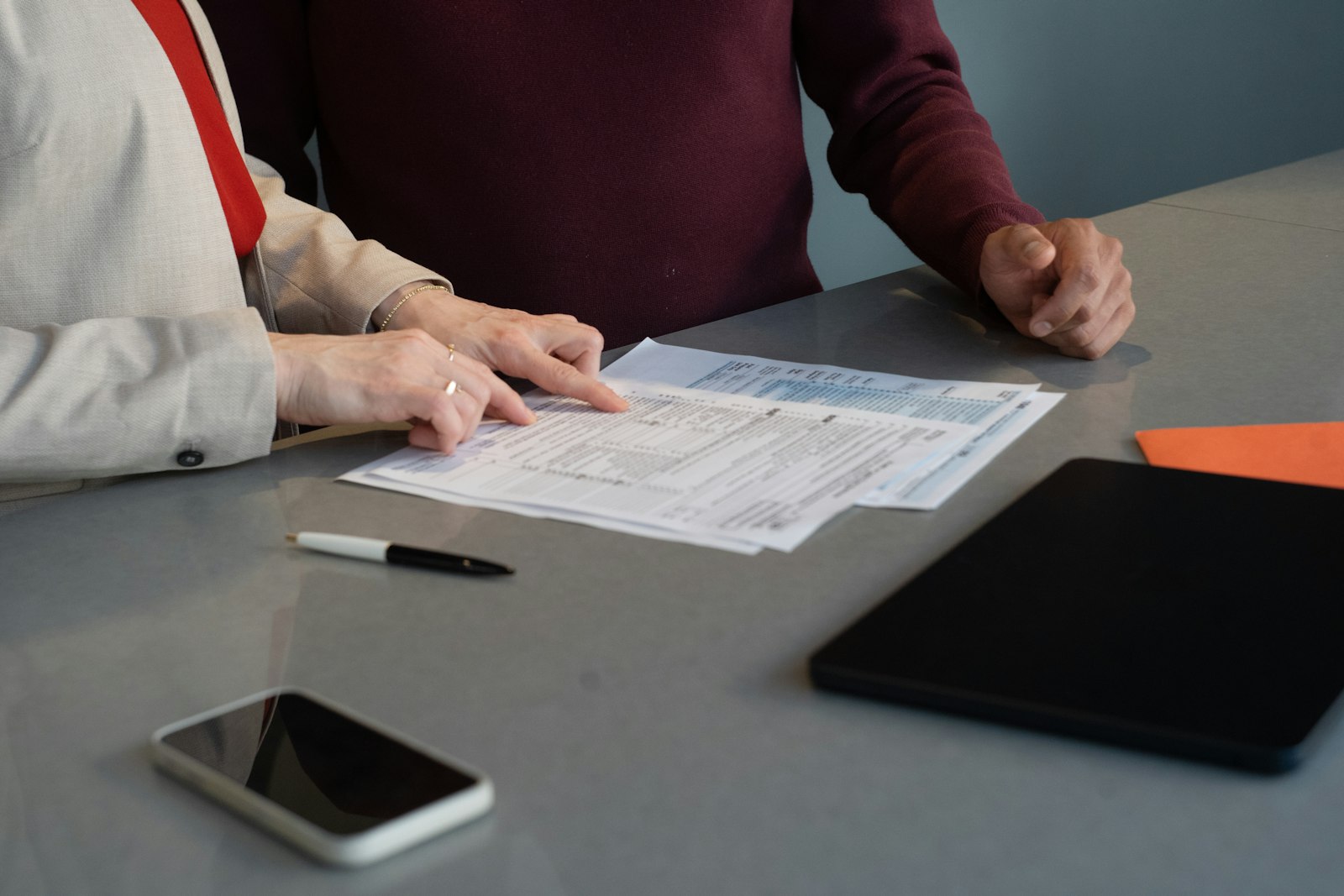 Two people reviewing printed quality records at a table during an ISO 13485 internal audit