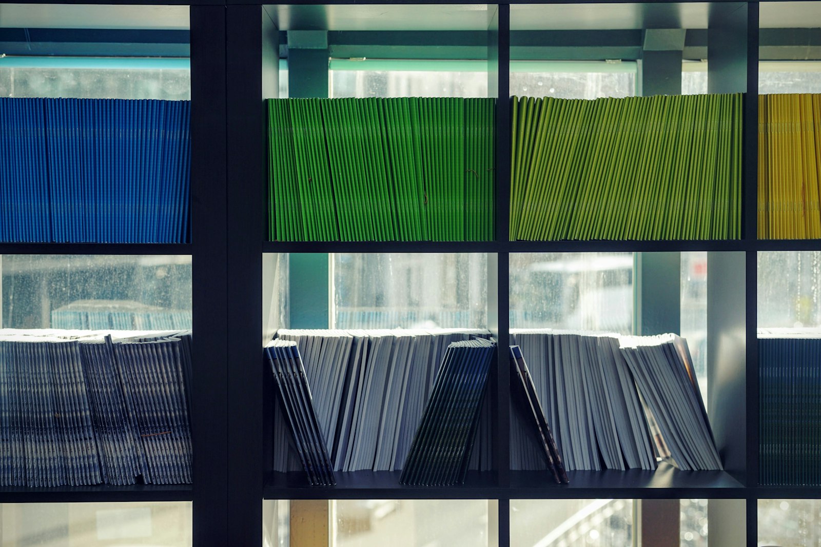 Colour-coded bound documents arranged on shelves, illustrating the technical file template post